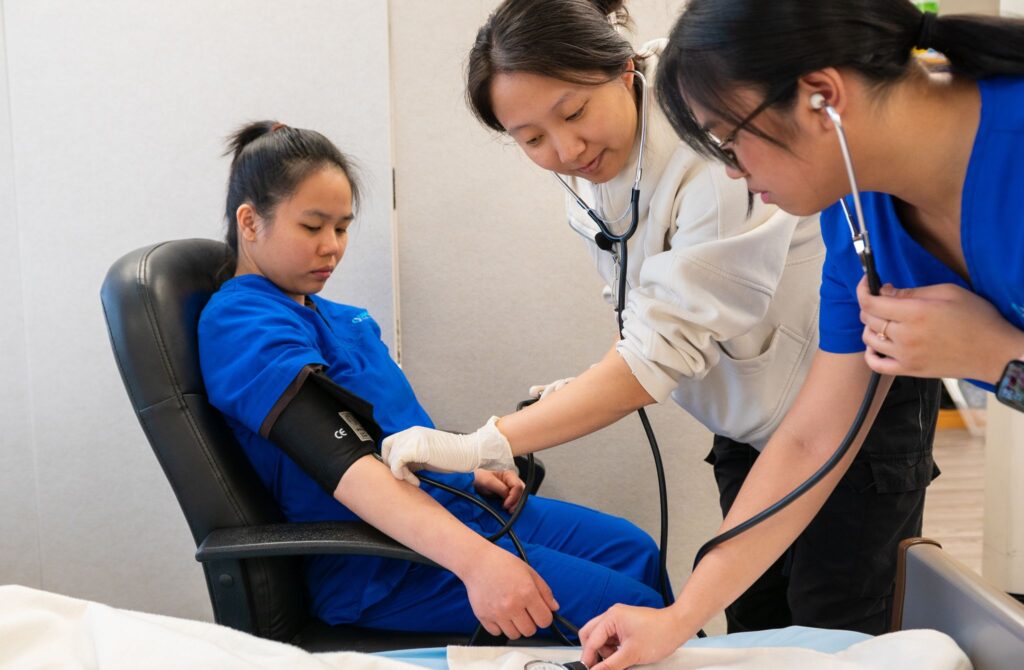 Healthcare professionals conducting a blood pressure check on a patient in a clinical setting.